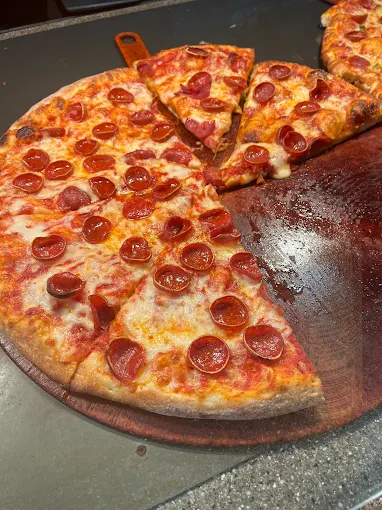 Sliced pepperoni pizza on the peel at Buscemi's